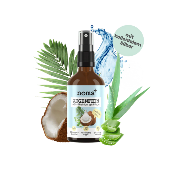 Braune Sprühflasche mit Aufschrift 'noms+ AUGENFEIN 2-in-1 Reinigung & Pflege', umgeben von Kokosnusshälfte, Aloe-vera-Blatt und Wasser-Spritzern.