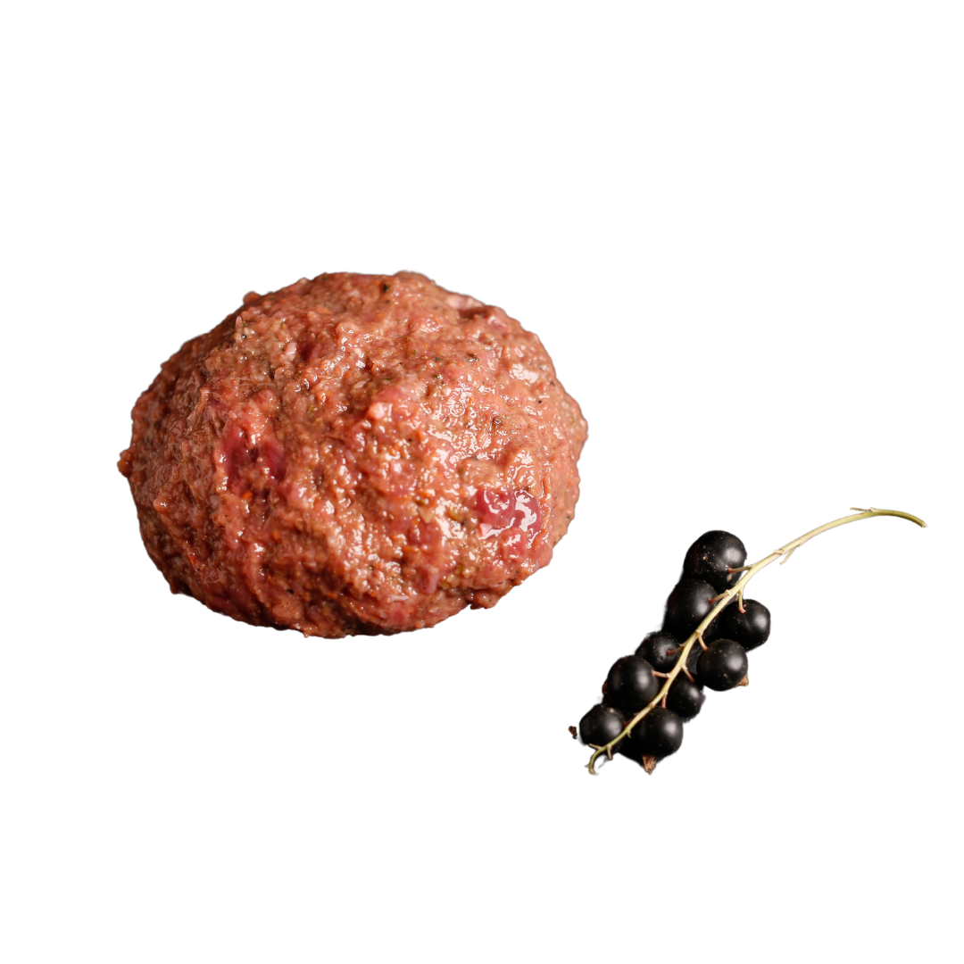 Eine "rohe Fleischkugel" und ein kleiner Zweig mit schwarzen Johannisbeeren auf transparentem Hintergrund.