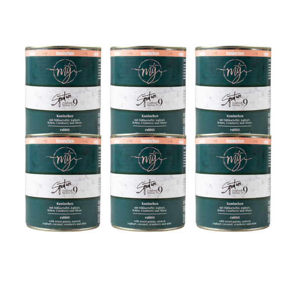 Sechs Dosen Hundefutter mit dunkel grünem Etikett. Aufschrift: my Signature, Dogfood Menue No. 9, Kaninchen und Zutaten wie Süßkartoffeln, Joghurt, Kokos, Cranberry, Minze
