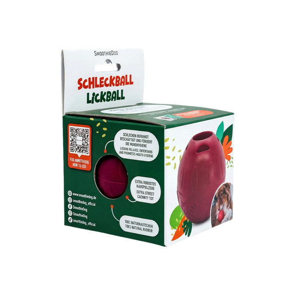 Verpackung eines roten Hundespielzeugs namens Schleckball Lickball aus Naturkautschuk mit Karottenabbildung und Texten zu Eigenschaften