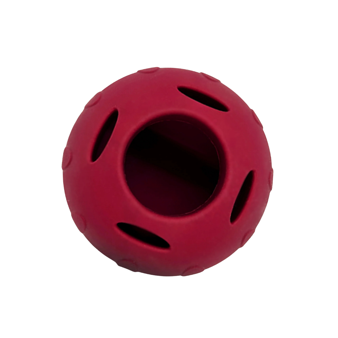 Rotes Hundespielzeugs aus Naturkautschuk von oben mit einem großen Loch in der Mitte und vier kleineren umrandet