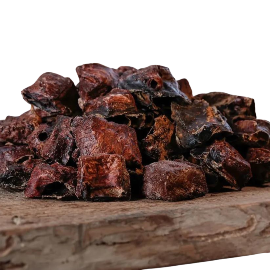 Eine große Menge an Barfgold Pferdelungenschmatzies, 200g, auf einem Holzbrett. Die Stücke sind unregelmäßig geformt, braun bis schwarz.