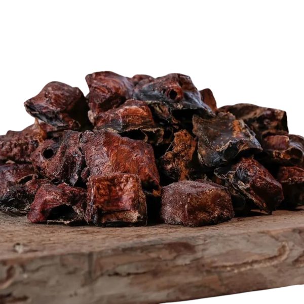 Eine große Menge an Barfgold Pferdelungenschmatzies, 200g, auf einem Holzbrett. Die Stücke sind unregelmäßig geformt, braun bis schwarz.