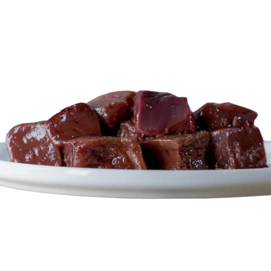 Stücke von Rindeleber auf einem weißen Teller, glänzende Oberfläche, in verschiedenen Größen und Formen, 500g. Marke: Barfgold.