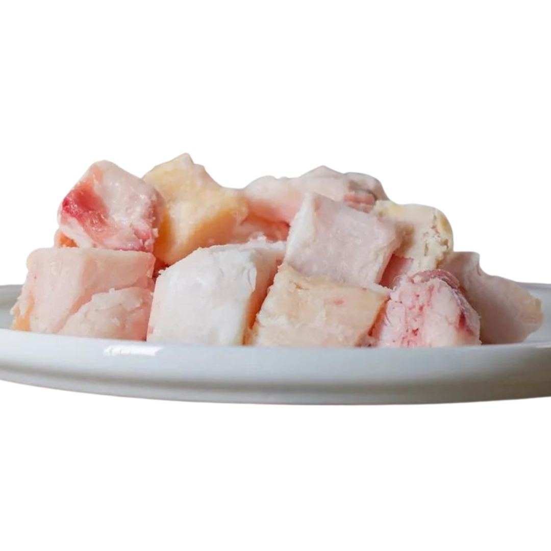 Stücke von Rinderfett in verschiedenen Größen und Farben auf einem weißen Teller. Marke 'Barfgold', 500g. 