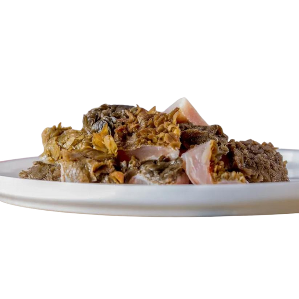 Barfgold Rinderpansen auf einem weißen Teller, in unregelmäßigen Stücken, mit einer groben, faserigen Textur.