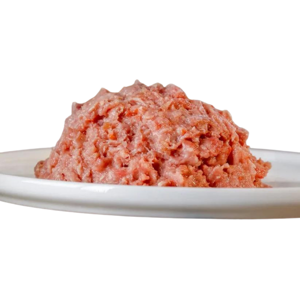 Haufen von gewolftem Hühnerfleisch auf einem weißen Teller. Produkt von Barfgold, 1 kg, für Tiere