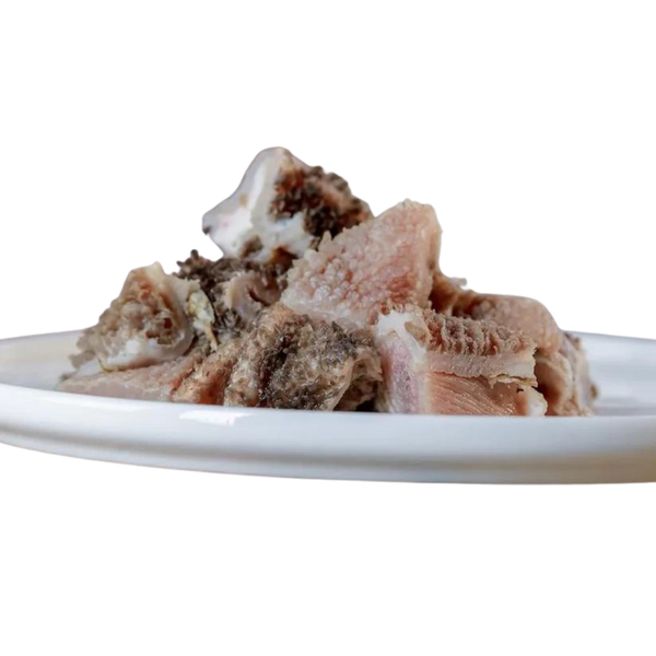 Stücke von Lamm-Pansen auf einem weißen Teller. Die Fleischstücke sind unregelmäßig geformt und zeigen eine Mischung aus hellen und dunklen Bereichen.