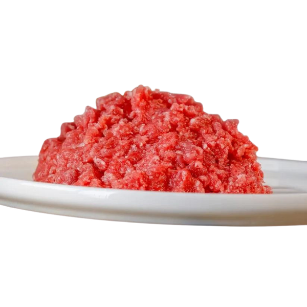 Rote, gewolfte Kaninchenfleischmasse auf einem weißen Teller. Die Masse hat eine grobe, krümelige Textur.