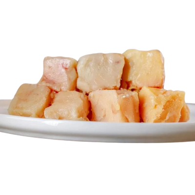 Sechs Stücke Pferdefett in Würfelform auf einem weißen Teller. Die Würfel sind in verschiedenen Farbtönen von beige bis hellbraun.