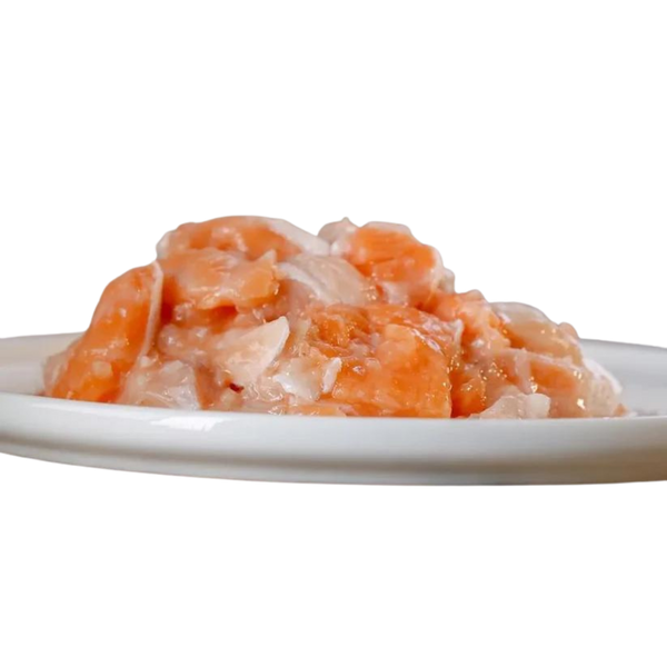 Weißer Teller mit Lachs und Fett. Stücke sind in verschiedenen Formen und Größen. Marke Barfgold