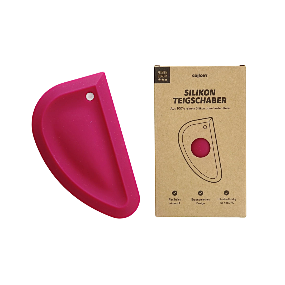 Rosa Silikon-Teigschaber in halbrunder Form neben einer braunen Verpackung mit dem Text 'SILIKON TEIGSCHABER'.