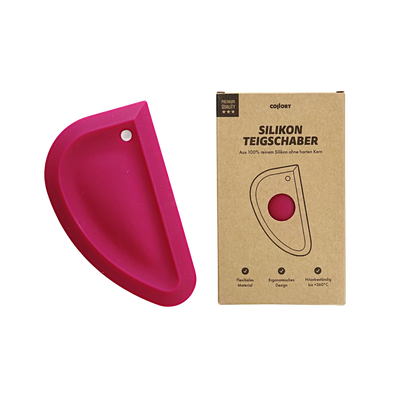 Rosa Silikon-Teigschaber in halbrunder Form neben einer braunen Verpackung mit dem Text 'SILIKON TEIGSCHABER'.