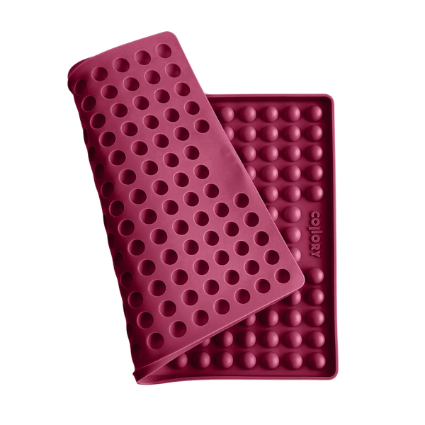 Rote Silikonmatte mit Noppen, die eine abgerundete Form hat. Die Matte hat eine wellenförmige Struktur.