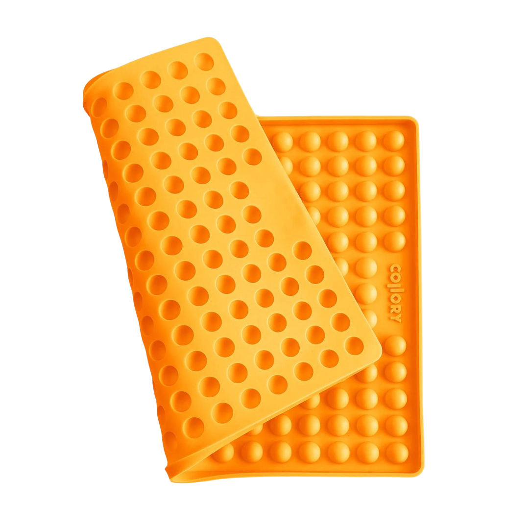 Orange Silikonmatte mit Noppen, die eine abgerundete Form hat. Die Matte hat eine wellenförmige Struktur.