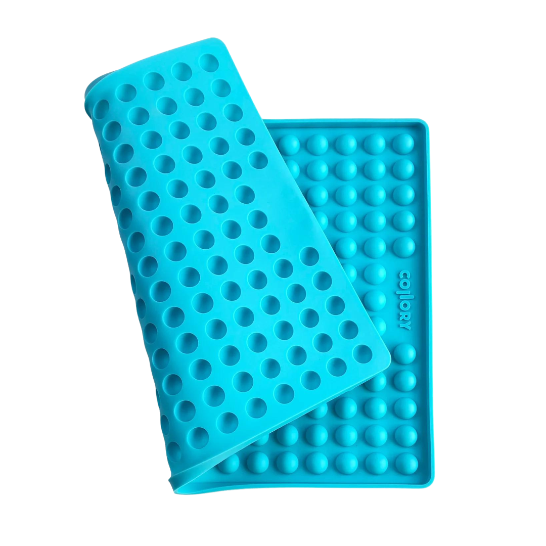 Blaue Silikonmatte mit Noppen, die eine abgerundete Form hat. Die Matte hat eine wellenförmige Struktur.