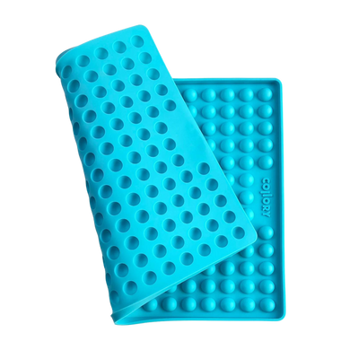 Blaue Silikonmatte mit Noppen, die eine abgerundete Form hat. Die Matte hat eine wellenförmige Struktur.