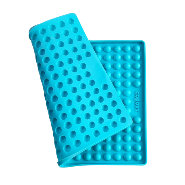 Blaue Silikonmatte mit Noppen, die eine abgerundete Form hat. Die Matte hat eine wellenförmige Struktur.