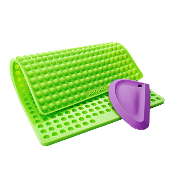 Grüne Silikonmatte mit Noppen und einer lila Kante, die eine abgerundete Form hat. Die Matte hat eine wellenförmige Struktur.