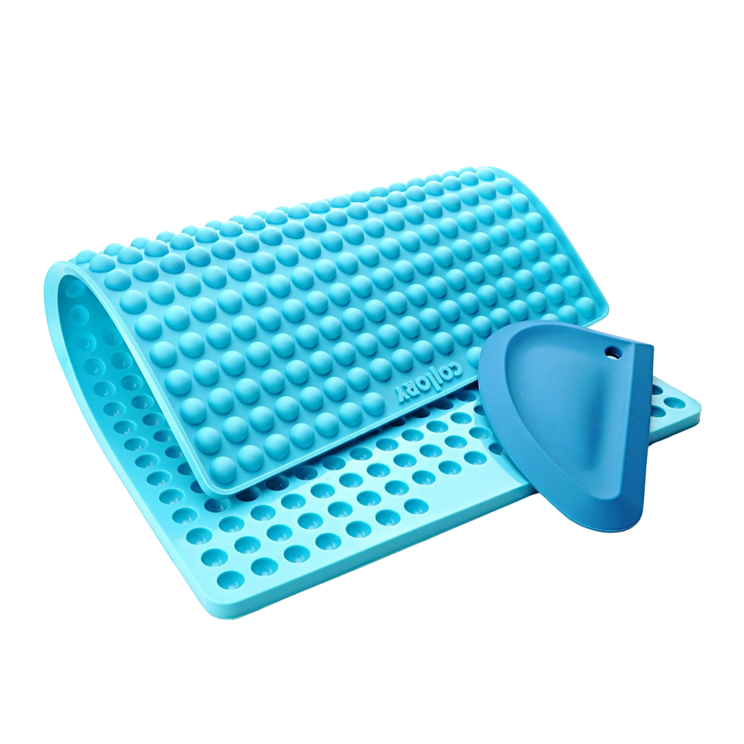 Türkise Silikonmatte mit Noppen und einer blauen Kante, die eine abgerundete Form hat. Die Matte hat eine wellenförmige Struktur.