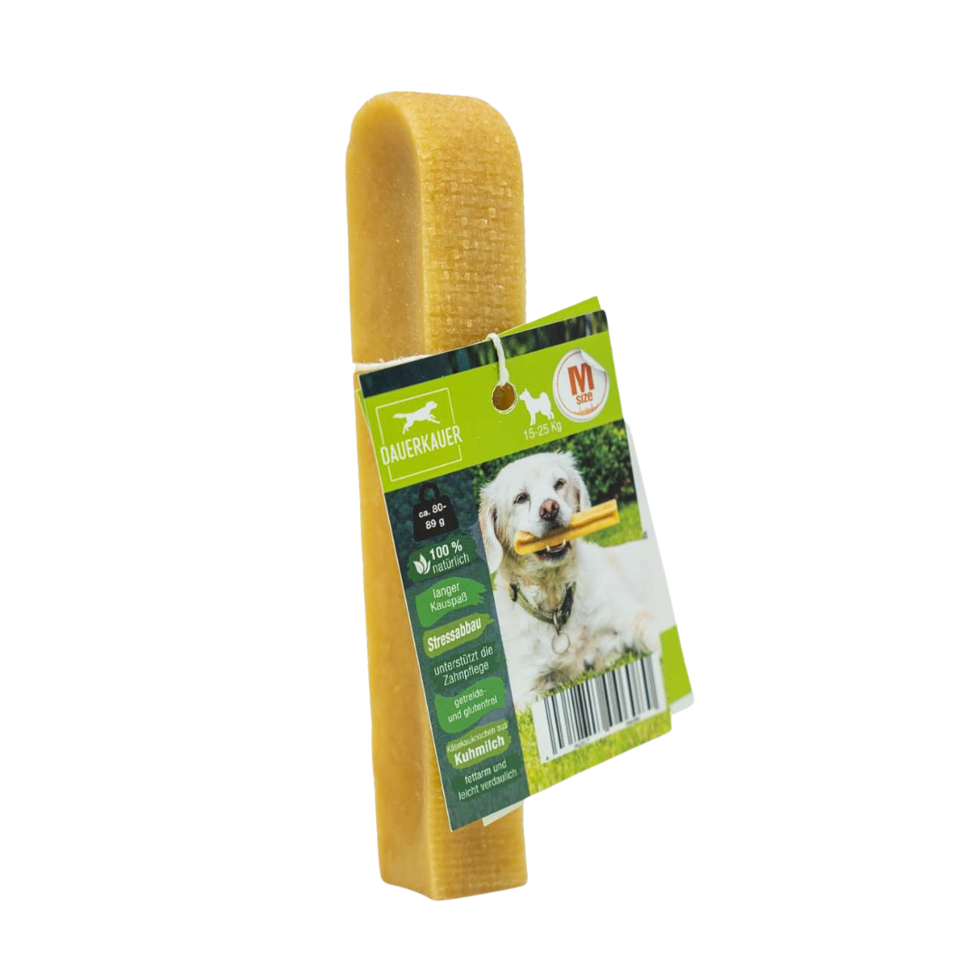 Gelber Hundekauartikel mit einer grünen Verpackung. Auf der Verpackung ist ein Hund mit einem Kauknochen abgebildet - Size M. Sichtbarer Barcode.