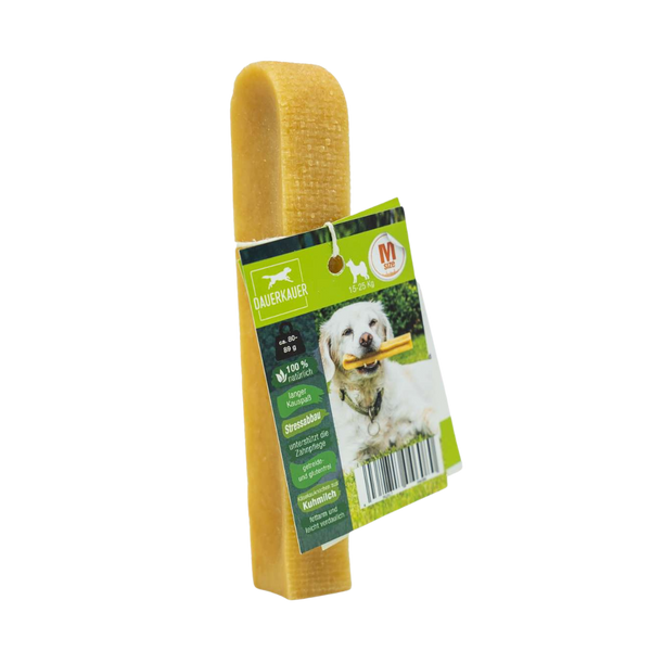 Gelber Hundekauartikel mit einer grünen Verpackung. Auf der Verpackung ist ein Hund mit einem Kauknochen abgebildet - Size M. Sichtbarer Barcode.