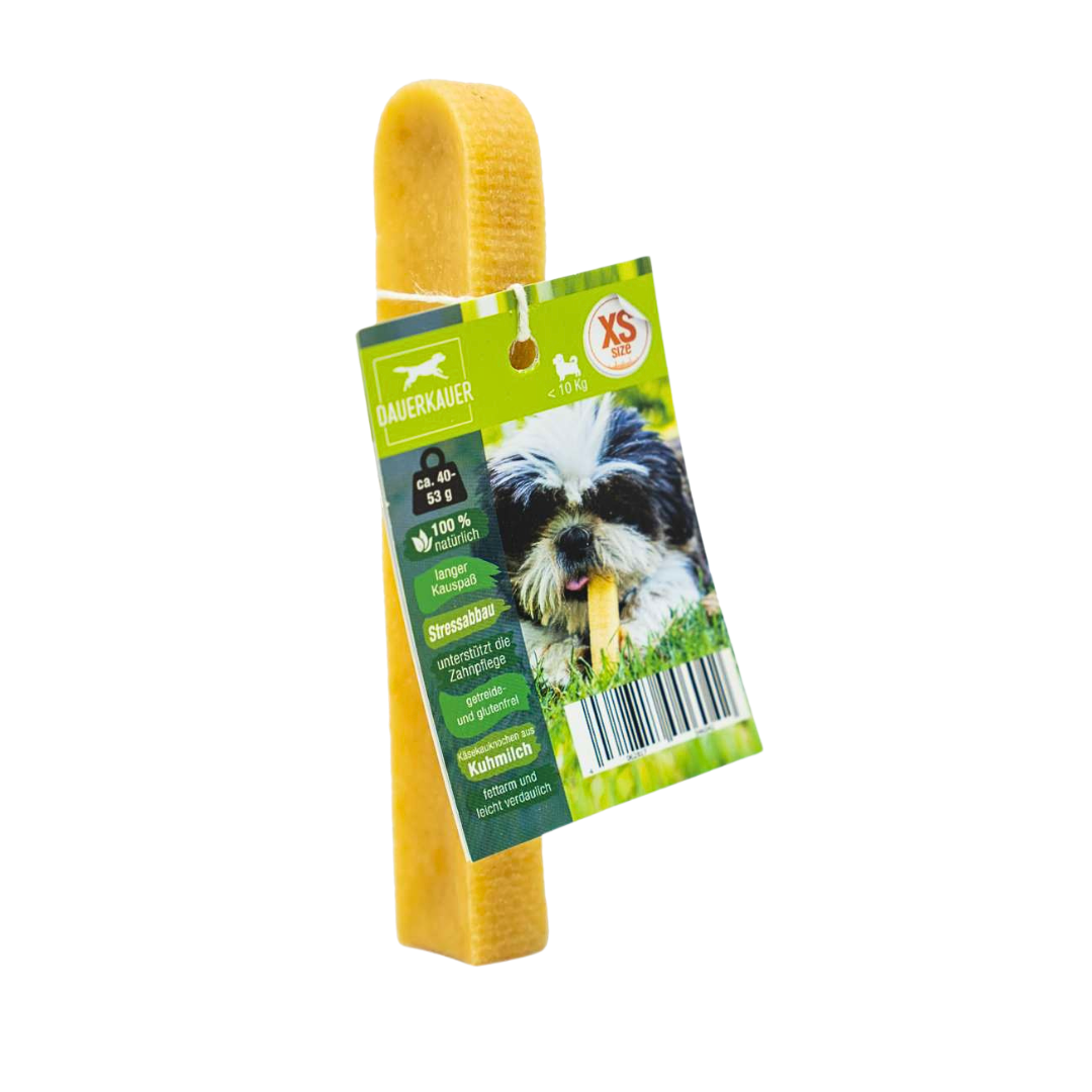 Gelber Hundekauartikel mit einer grünen Verpackung. Auf der Verpackung ist ein Hund mit einem Kauknochen abgebildet - Size XS. Sichtbarer Barcode.