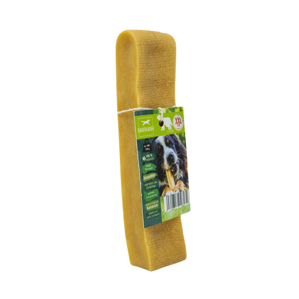 Gelber Hundekauartikel mit einer grünen Verpackung. Auf der Verpackung ist ein Hund mit einem Kauknochen abgebildet - Size XXL. Sichtbarer Barcode.