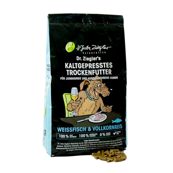 Schwarze Verpackung von Dr. Ziegler's kaltgepresstem Trockenfutter für Hunde mit Illustration eines Hundes, der an einem Tisch sitzt und Wein trinkt, Text 'Weissfisch & Vollkornreis' und Futterstückchen daneben.