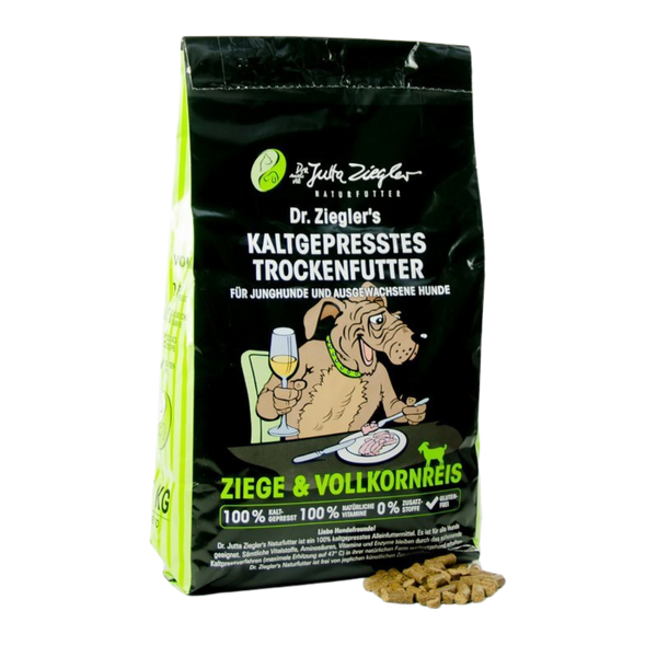 Schwarze Verpackung von Dr. Ziegler's kaltgepresstem Trockenfutter für Hunde mit Illustration eines Hundes, der an einem Tisch sitzt und Wein trinkt, Text 'Ziege & Vollkornreis' und Futterstückchen daneben.