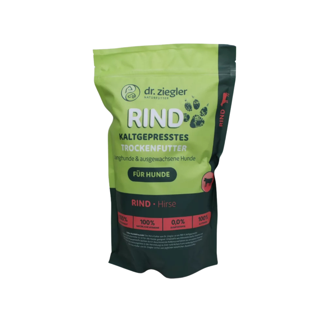 Grünes und schwarzes Futterbeutel mit Aufschrift 'dr. ziegler NATURFUTTER RIND KALTGEPRESSTES TROCKENFUTTER für Hunde' und Symbolen von Pfoten und Hund.