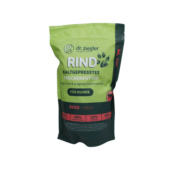 Grünes und schwarzes Futterbeutel mit Aufschrift 'dr. ziegler NATURFUTTER RIND KALTGEPRESSTES TROCKENFUTTER für Hunde' und Symbolen von Pfoten und Hund.