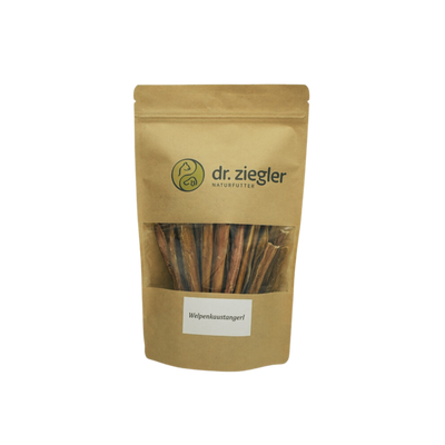 Braune Verpackung mit dem Logo 'dr. ziegler' und der Aufschrift 'Welpenkaustangerl'. Sichtbare Kaustangen im Inneren der Tüte.