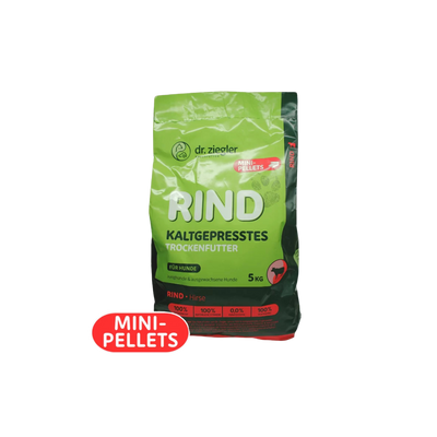 Grün-schwarze Verpackung von dr. ziegler mit der Aufschrift 'RIND KALTGEPRESSTES TROCKENFUTTER' für Hunde, 5 kg, mit rotem Aufkleber 'MINI-PELLETS'.