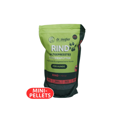 Grün-schwarze Verpackung von dr. ziegler mit der Aufschrift 'RIND KALTGEPRESSTES TROCKENFUTTER' für Hunde, mit rotem Aufkleber 'MINI-PELLETS'.