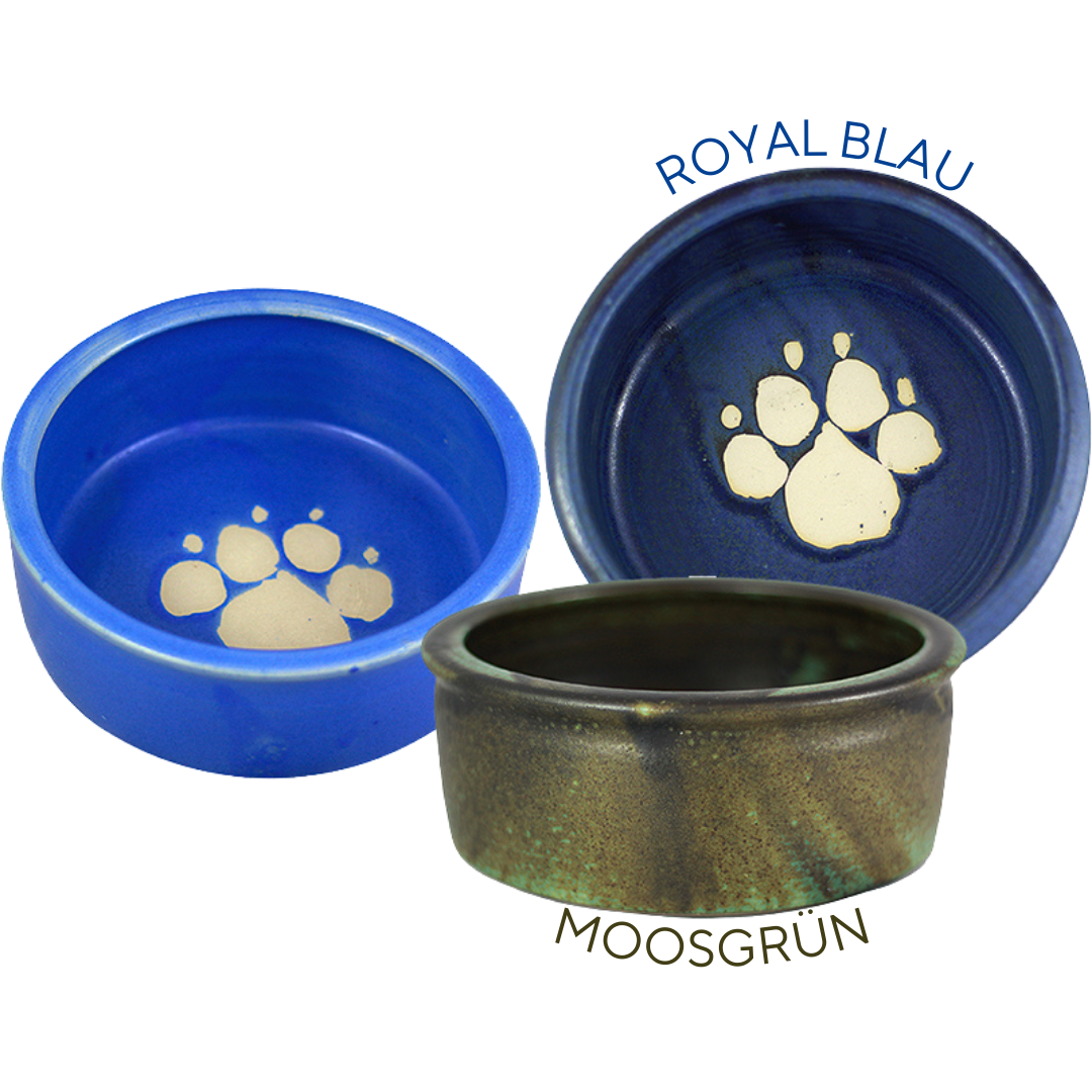 Drei Keramiknäpfe in verschiedenen Farben: ein blauer Napf mit einem Pfotenabdruck, ein moosgrüner Napf und ein weiterer Napf in dunkelblau.
