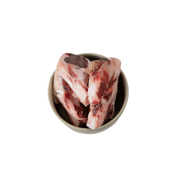 Schale mit mehreren rohen Kalbsknochen mit Fleischresten