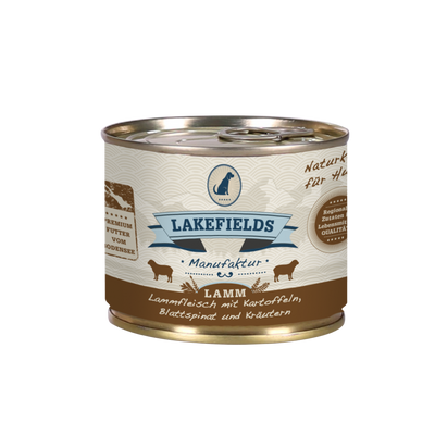 Runde Dose mit dem Etikett 'LAKEFIELDS', Inhalt: Weidelamm mit Blattspinat, Kräutern und Kartoffeln. Die Dose hat einen metallischen Glanz und eine braune Farbfläche.