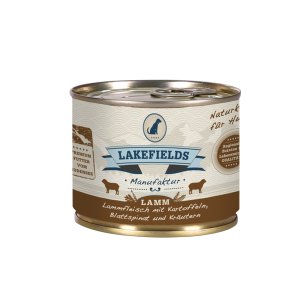 Runde Dose mit dem Etikett 'LAKEFIELDS', Inhalt: Weidelamm mit Blattspinat, Kräutern und Kartoffeln. Die Dose hat einen metallischen Glanz und eine braune Farbfläche.