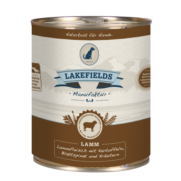 Runde Dose mit dem Etikett 'LAKEFIELDS', Inhalt: Weidelamm mit Blattspinat, Kräutern und Kartoffeln. Die Dose hat einen metallischen Glanz und eine braune Farbfläche.