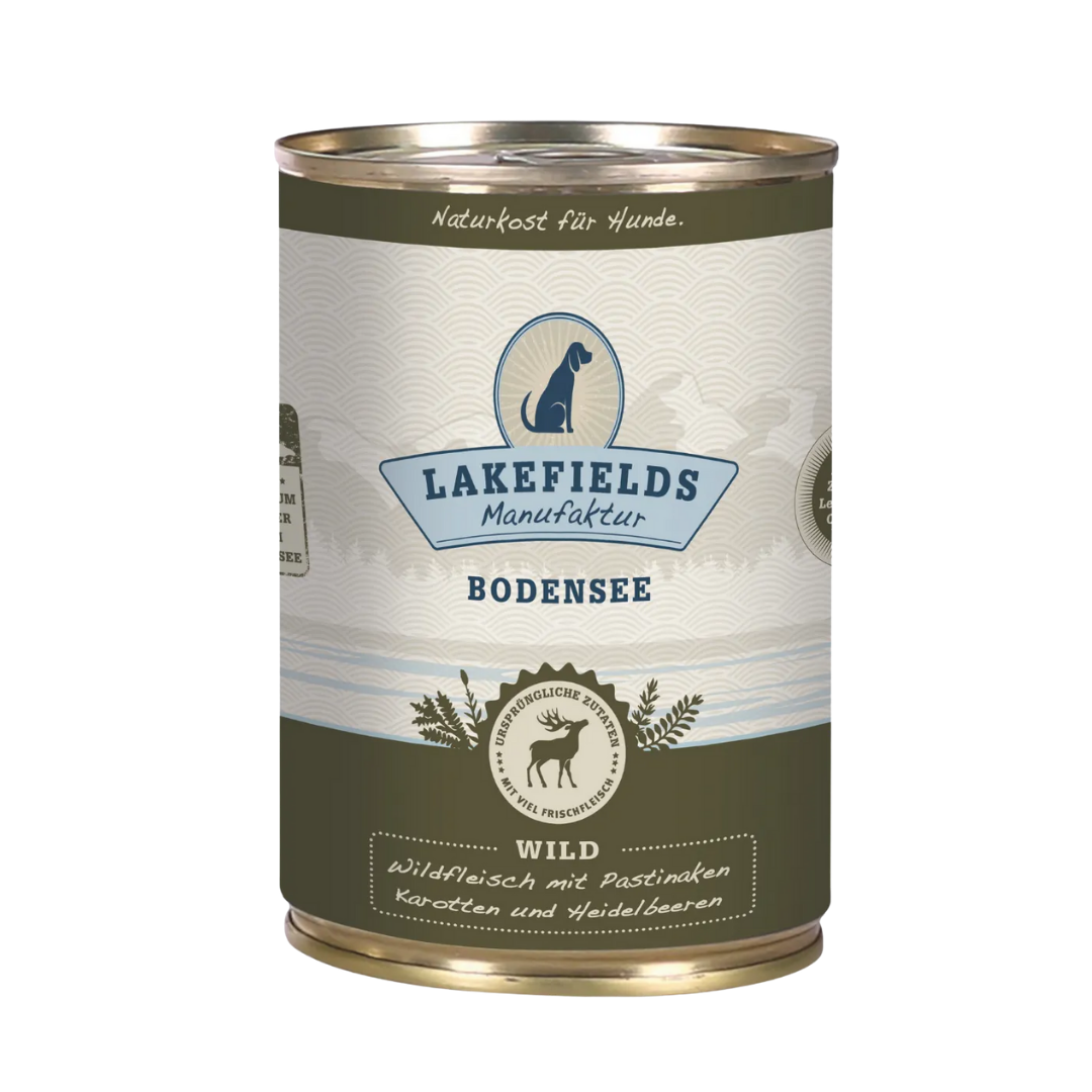 Runde Dose mit dem Etikett 'LAKEFIELDS', Inhalt: Wild mit Pastinaken, Karotten, Heidelbeeren. Die Dose hat einen metallischen Glanz und grüner Farbfläche.