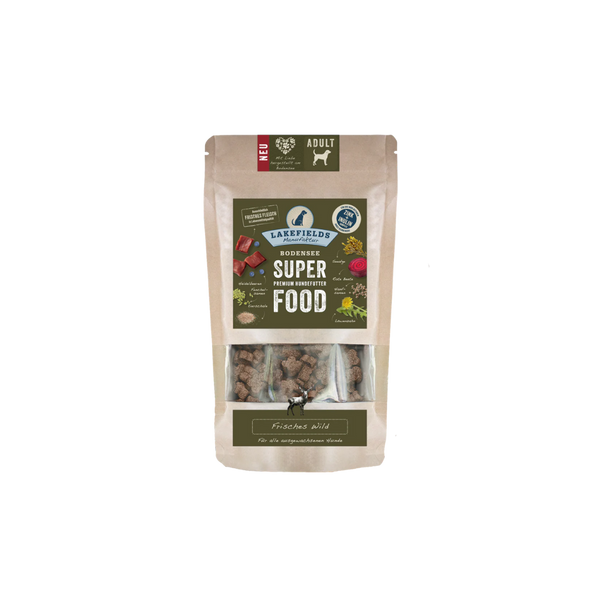 Verpackung von Lakefields Superfood für Hunde, 130g. Grüne Tüte mit Bildern von Wild, Kräutern und dem Text 'ADULT'.