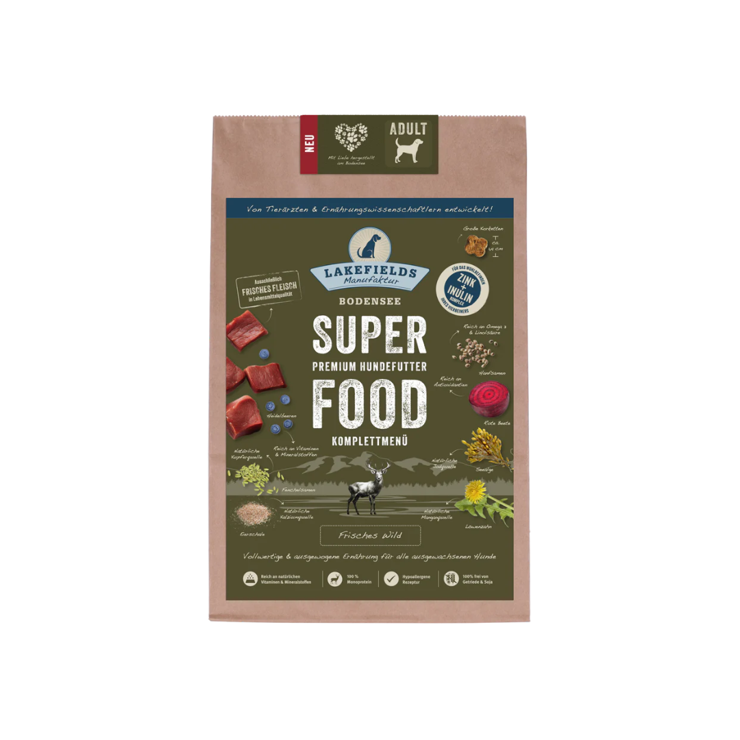 Verpackung von Lakefields Superfood für Hunde, 1 kg. Grüne Tüte mit Bildern von Wild, Kräutern und dem Text 'ADULT'.