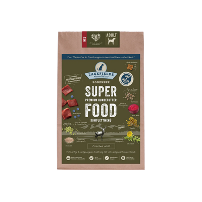 Verpackung von Lakefields Superfood für Hunde, 1 kg. Grüne Tüte mit Bildern von Wild, Kräutern und dem Text 'ADULT'.