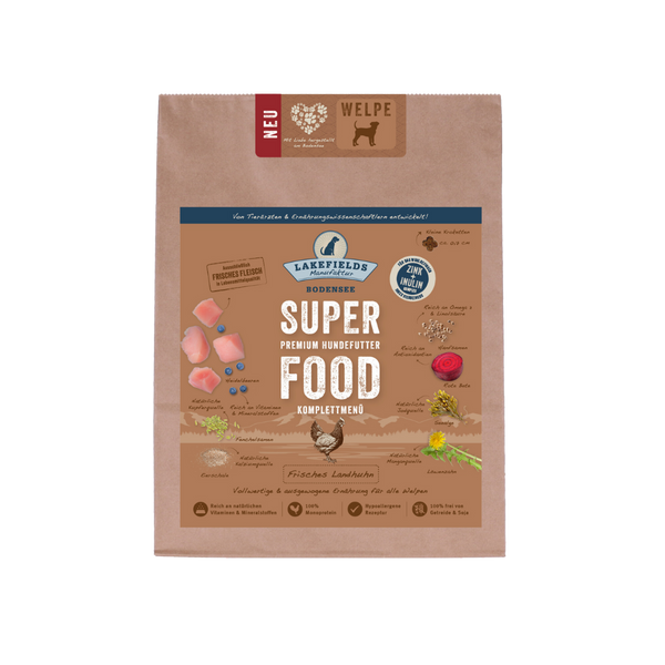 Verpackung von Lakefields Superfood für Hunde, 2.5 kg. Braune Tüte mit Bildern von Landhuhn, Kräutern und dem Text 'NEU' und 'WELPE'.