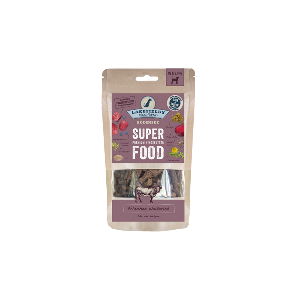 Verpackung von Lakefields Superfood für Hunde, 130g. Violette Tüte mit Bildern von Weiderind, Kräutern und dem Text 'WELPEN'.