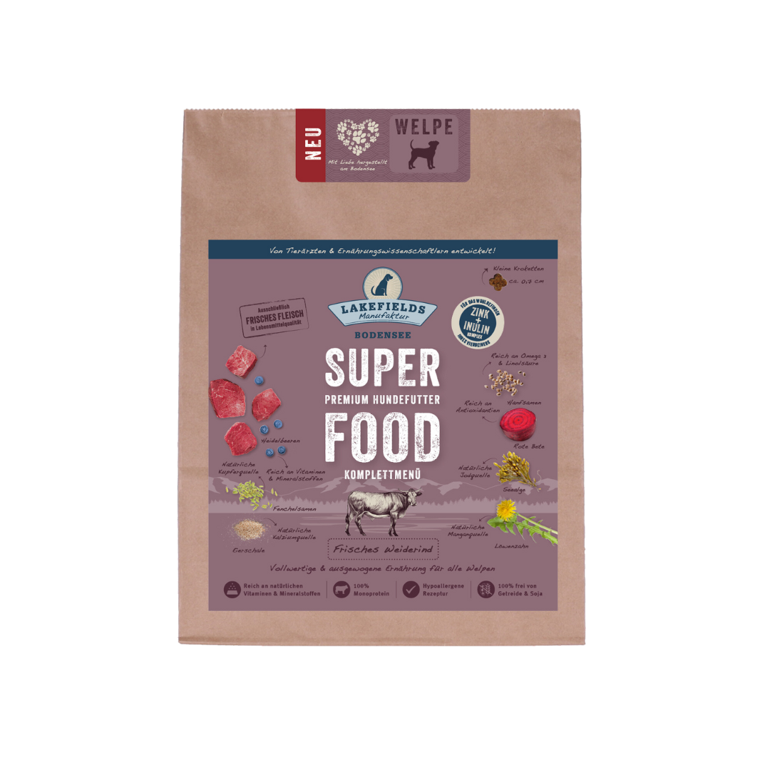 Verpackung von Lakefields Superfood für Hunde, 1 kg. Violette Tüte mit Bildern von Weiderind, Kräutern und dem Text 'WELPEN'.