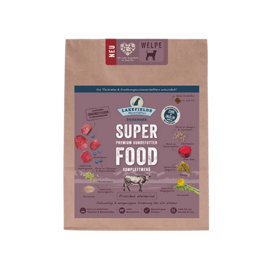 Verpackung von Lakefields Superfood für Hunde, 1 kg. Violette Tüte mit Bildern von Weiderind, Kräutern und dem Text 'WELPEN'.