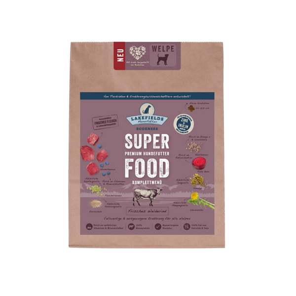 Verpackung von Lakefields Superfood für Hunde, 1 kg. Violette Tüte mit Bildern von Weiderind, Kräutern und dem Text 'WELPEN'.
