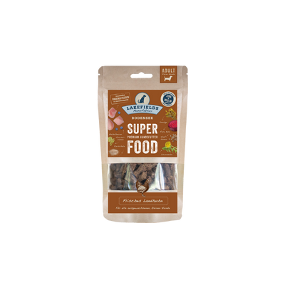 Verpackung von Lakefields Superfood für Hunde, 130g. Braune Tüte mit Bildern von Landhuhn, Kräutern und dem Text 'MINI Adult'.